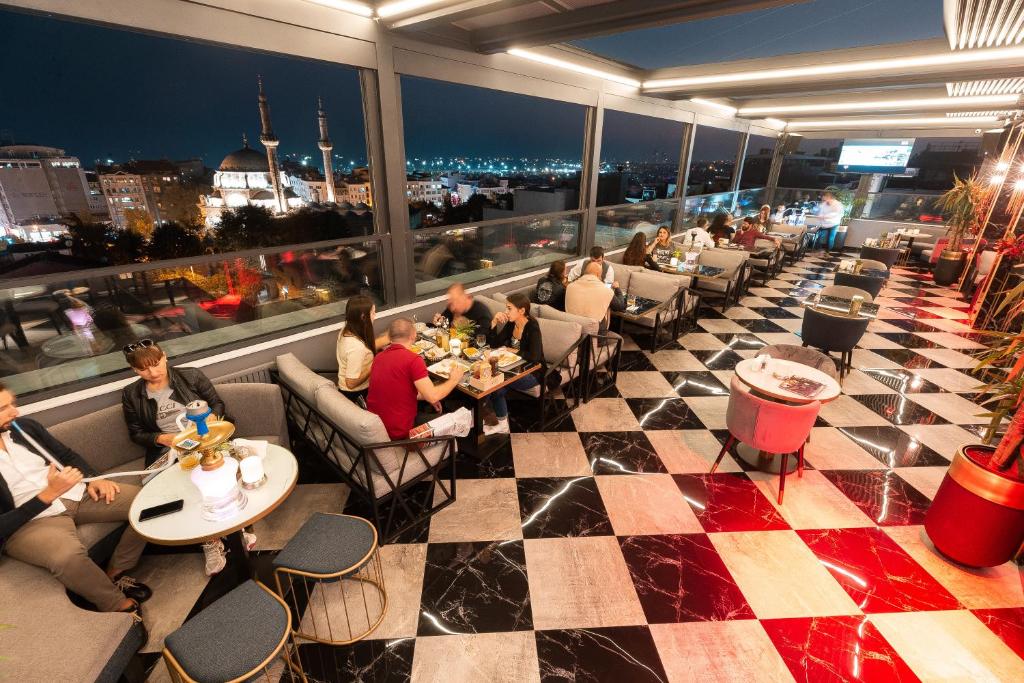 Grand Washington Hotel - a group of people sitting at tables in a restaurant at Grand Washington Hotel in Istanbul