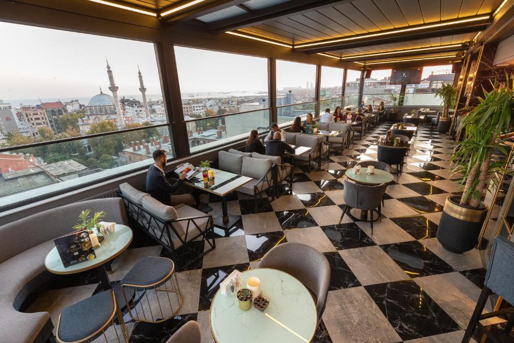 Grand Washington Hotel - a restaurant with tables and chairs and a large window at Grand Washington Hotel in Istanbul