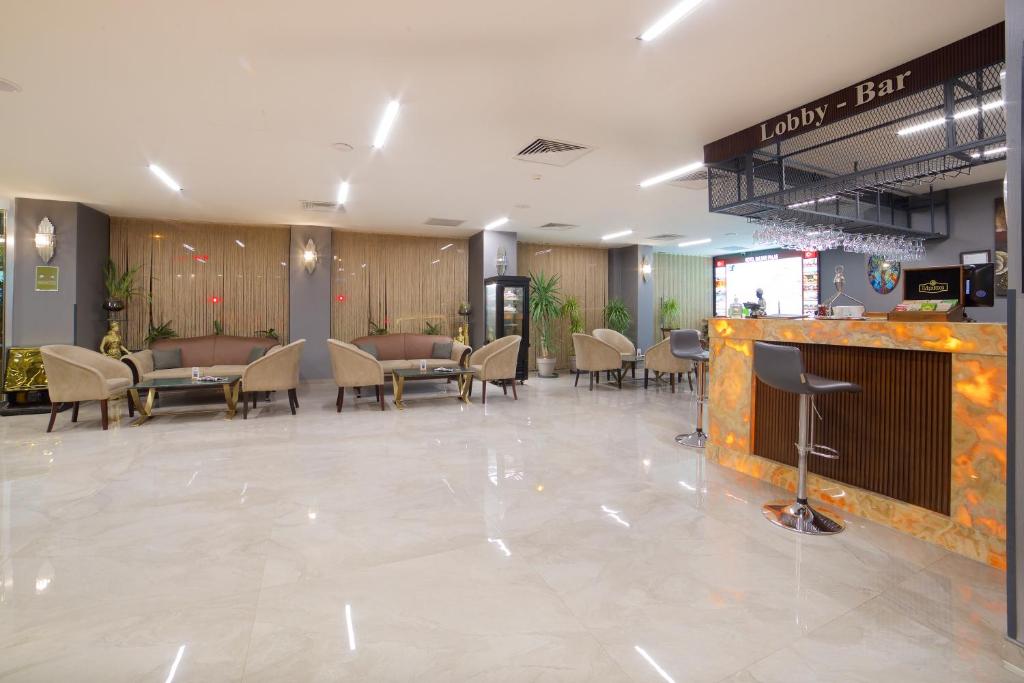 Hotel Bulvar Palas - a lobby of a hotel with tables and chairs at Hotel Bulvar Palas in Istanbul