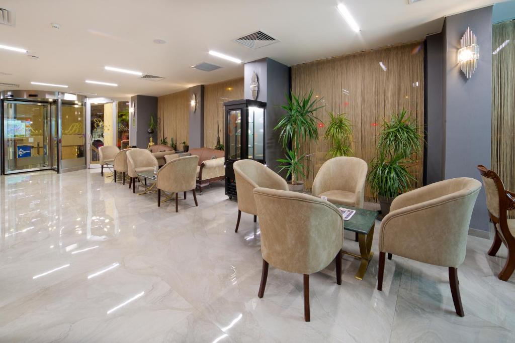 Hotel Bulvar Palas - a waiting room with chairs and tables in a lobby at Hotel Bulvar Palas in Istanbul