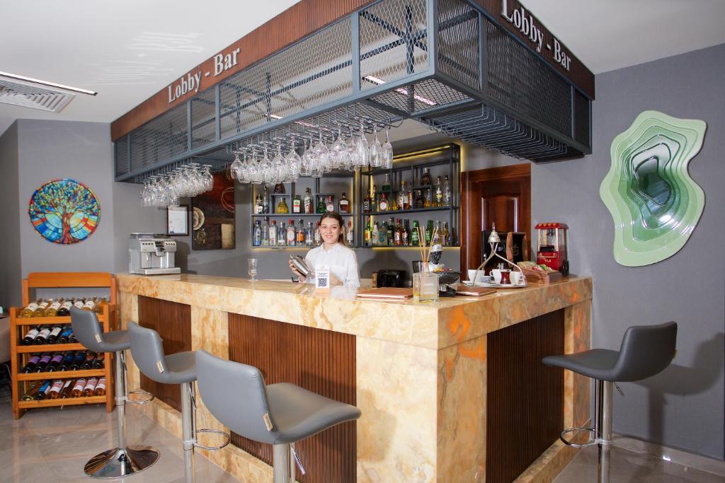 Hotel Bulvar Palas - a woman standing at a bar in a restaurant at Hotel Bulvar Palas in Istanbul