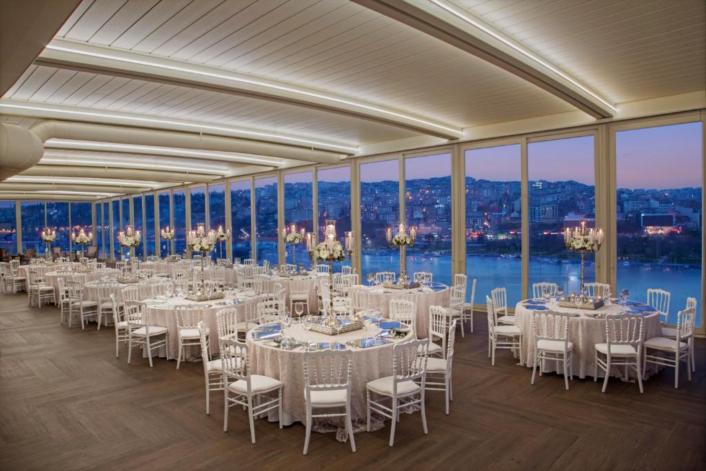 Lazzoni Hotel - a banquet hall with white tables and chairs and windows at Lazzoni Hotel in Istanbul