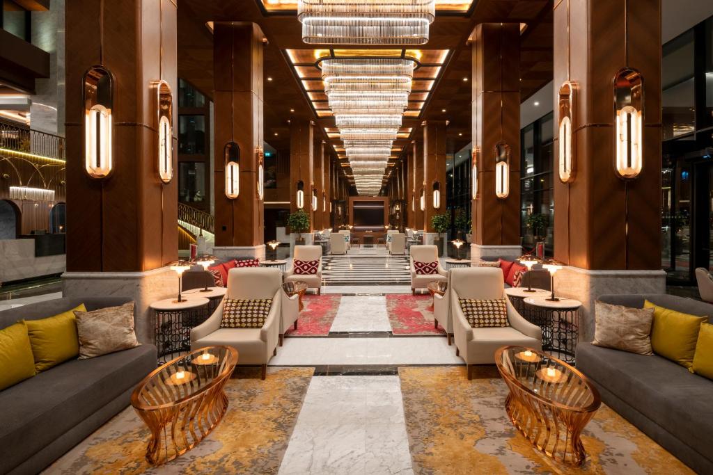 Mövenpick Hotel Istanbul Asia Airport - a lobby of a hotel with couches and tables at Mövenpick Hotel Istanbul Asia Airport in Istanbul