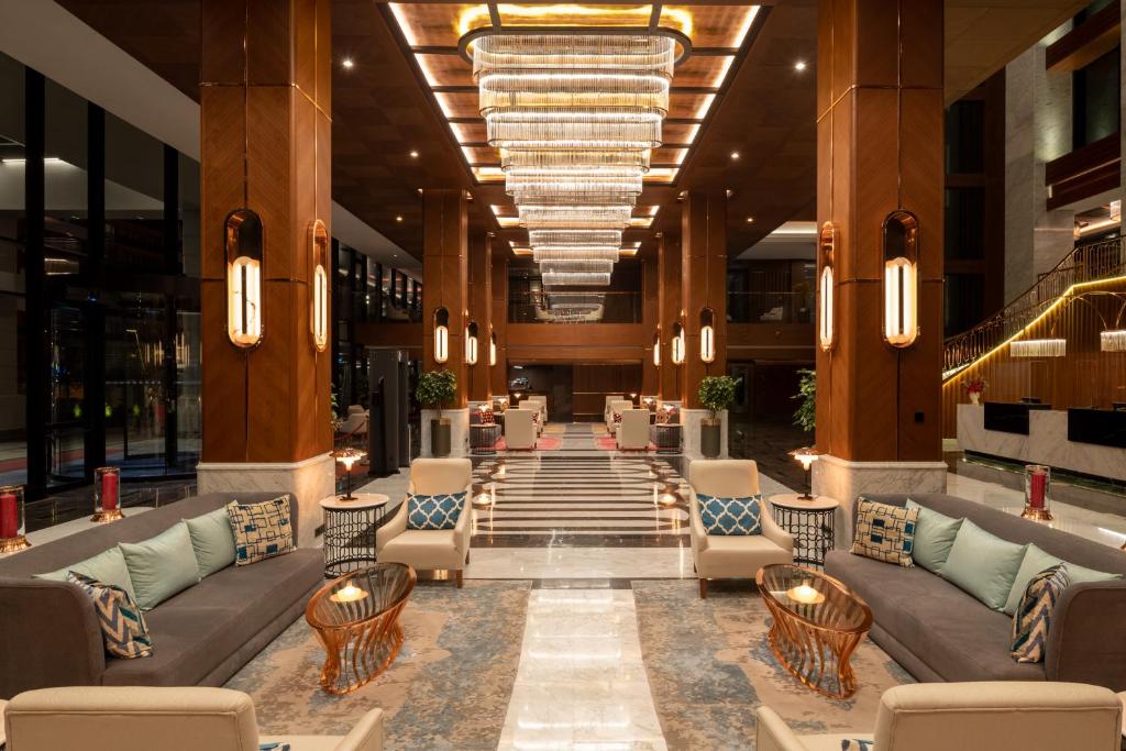 Mövenpick Hotel Istanbul Asia Airport - a lobby of a hotel with couches and chairs at Mövenpick Hotel Istanbul Asia Airport in Istanbul