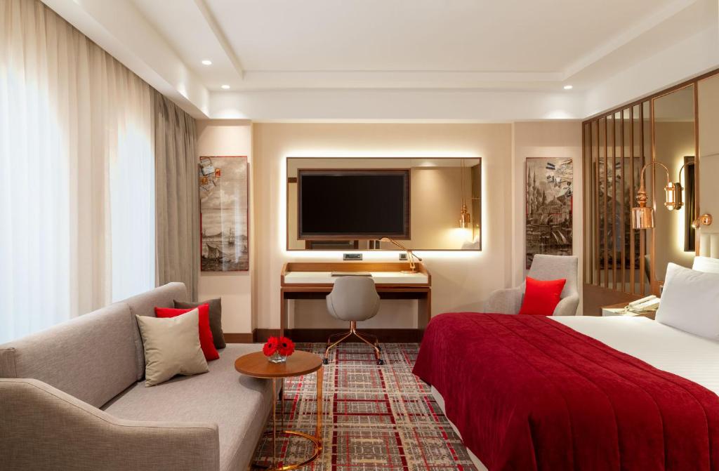 Mövenpick Hotel Istanbul Asia Airport - a hotel room with a bed and a couch and a television at Mövenpick Hotel Istanbul Asia Airport in Istanbul