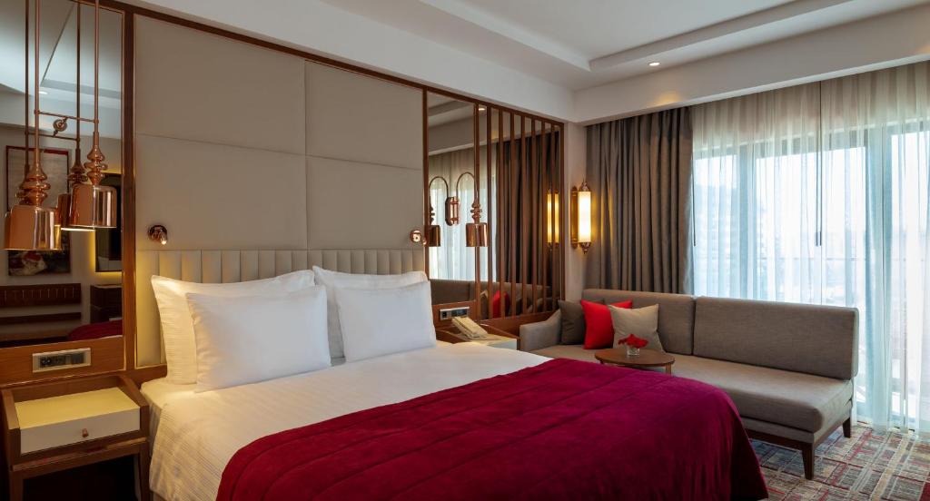 Mövenpick Hotel Istanbul Asia Airport - a hotel room with a bed and a couch at Mövenpick Hotel Istanbul Asia Airport in Istanbul