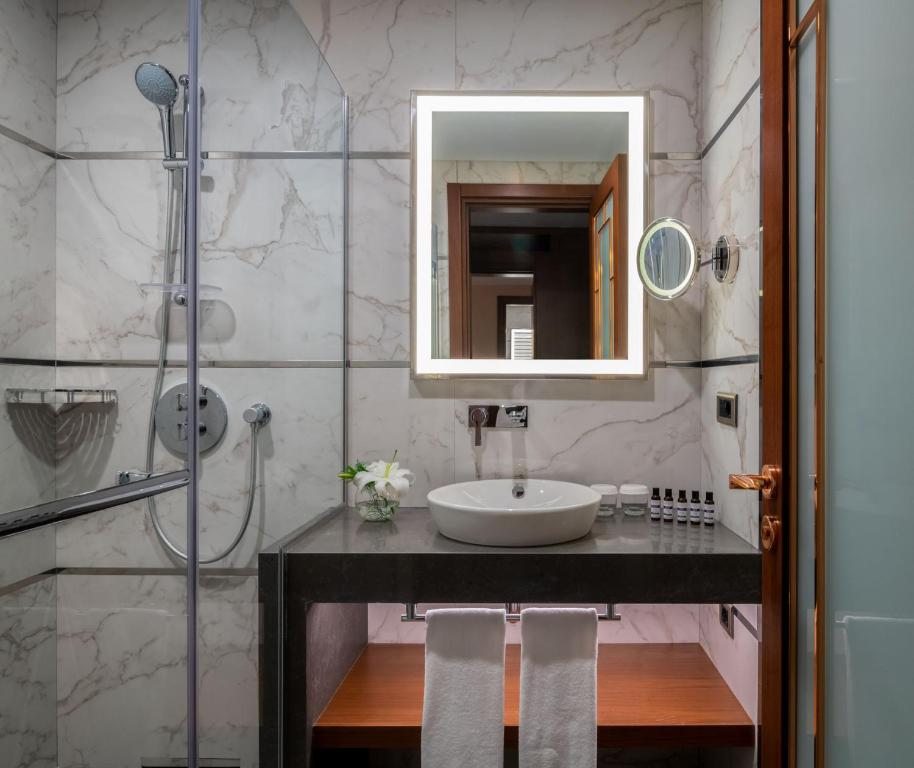 Mövenpick Hotel Istanbul Asia Airport - a bathroom with a sink and a mirror and a shower at Mövenpick Hotel Istanbul Asia Airport in Istanbul