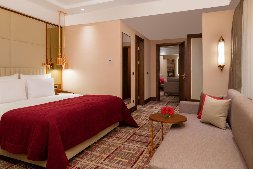 Mövenpick Hotel Istanbul Asia Airport - a hotel room with a bed and a couch at Mövenpick Hotel Istanbul Asia Airport in Istanbul