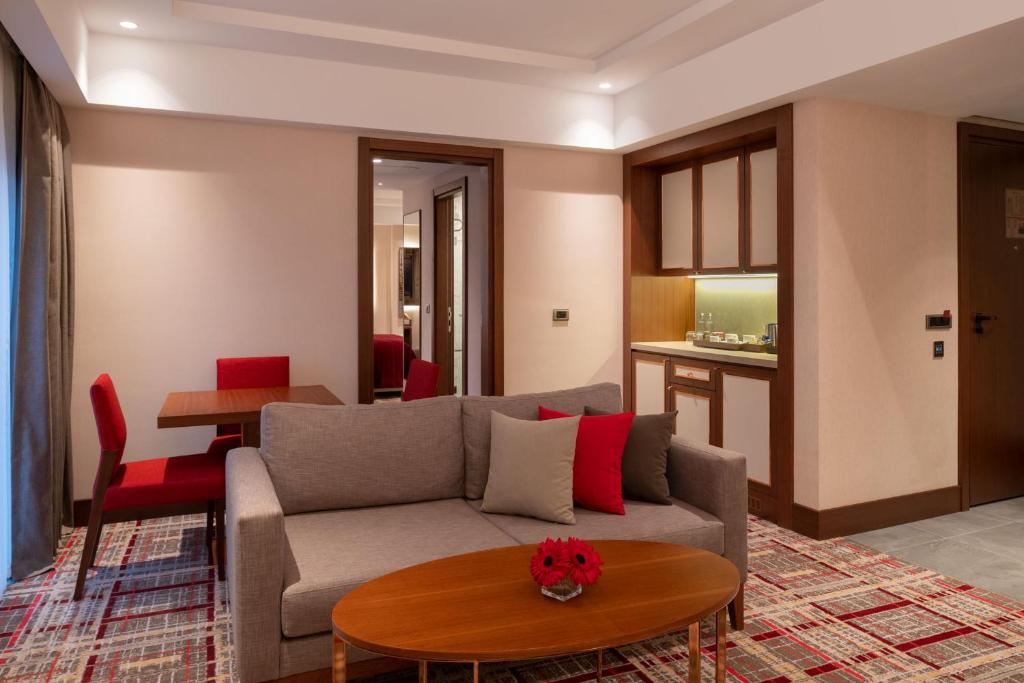 Mövenpick Hotel Istanbul Asia Airport - a living room with a couch and a table at Mövenpick Hotel Istanbul Asia Airport in Istanbul