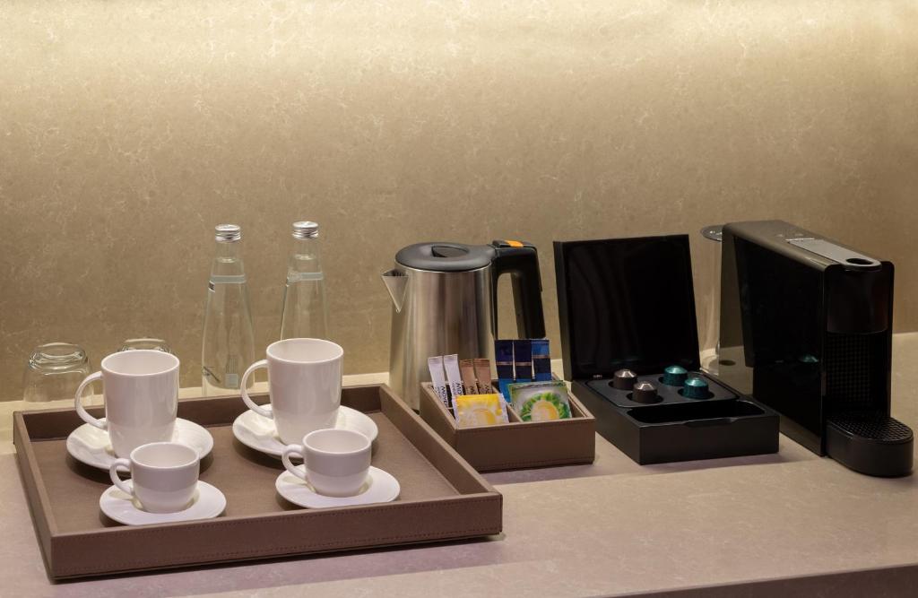 Mövenpick Hotel Istanbul Asia Airport - a tray with cups and saucers and a coffee maker at Mövenpick Hotel Istanbul Asia Airport in Istanbul