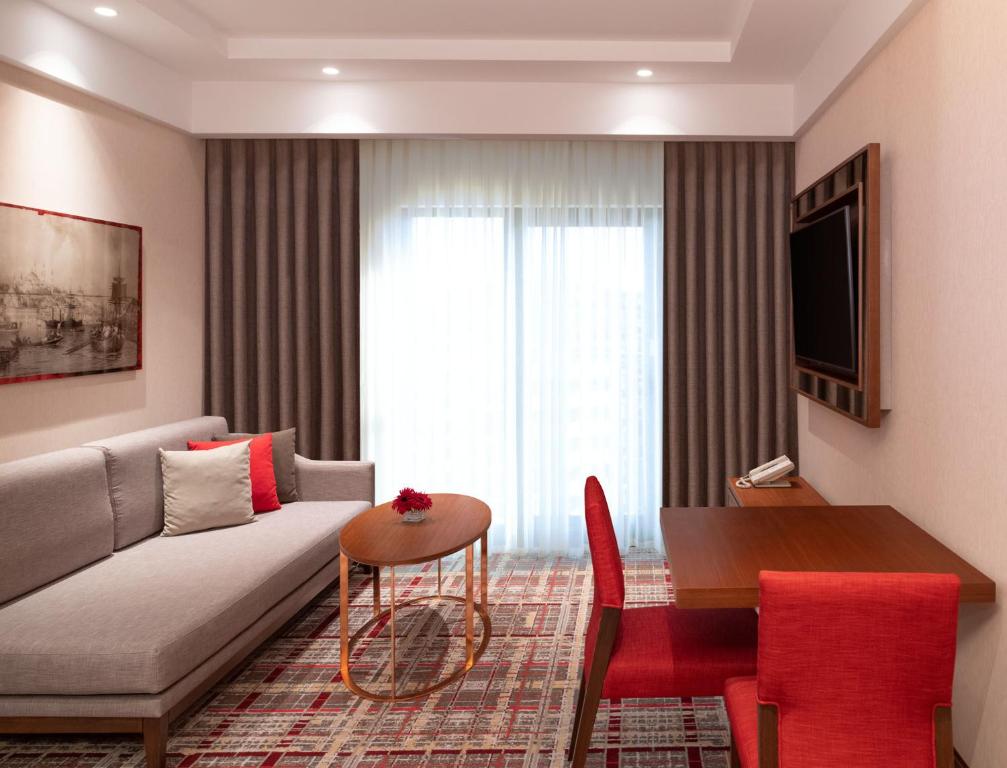Mövenpick Hotel Istanbul Asia Airport - a living room with a couch and a table at Mövenpick Hotel Istanbul Asia Airport in Istanbul