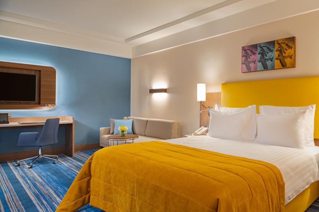 Mövenpick Hotel Istanbul Asia Airport - a hotel room with a bed and a desk at Mövenpick Hotel Istanbul Asia Airport in Istanbul