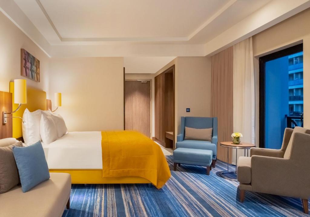 Mövenpick Hotel Istanbul Asia Airport - a hotel room with a bed and a chair at Mövenpick Hotel Istanbul Asia Airport in Istanbul