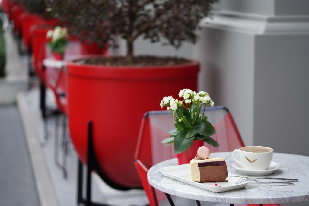 Mövenpick Hotel Istanbul Asia Airport - a table with a piece of cake and a cup of coffee at Mövenpick Hotel Istanbul Asia Airport in Istanbul