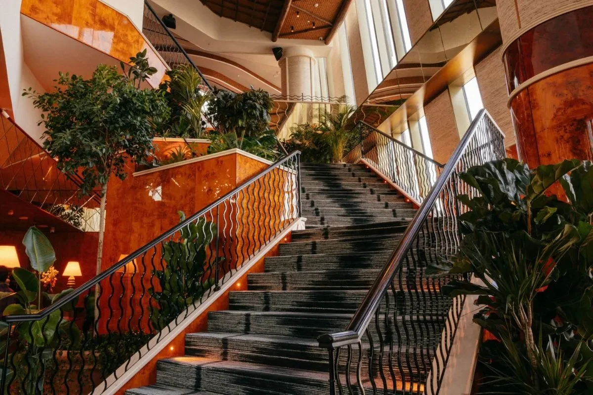 Elegant staircase with plants, Lion in the Sun Dubai interior.