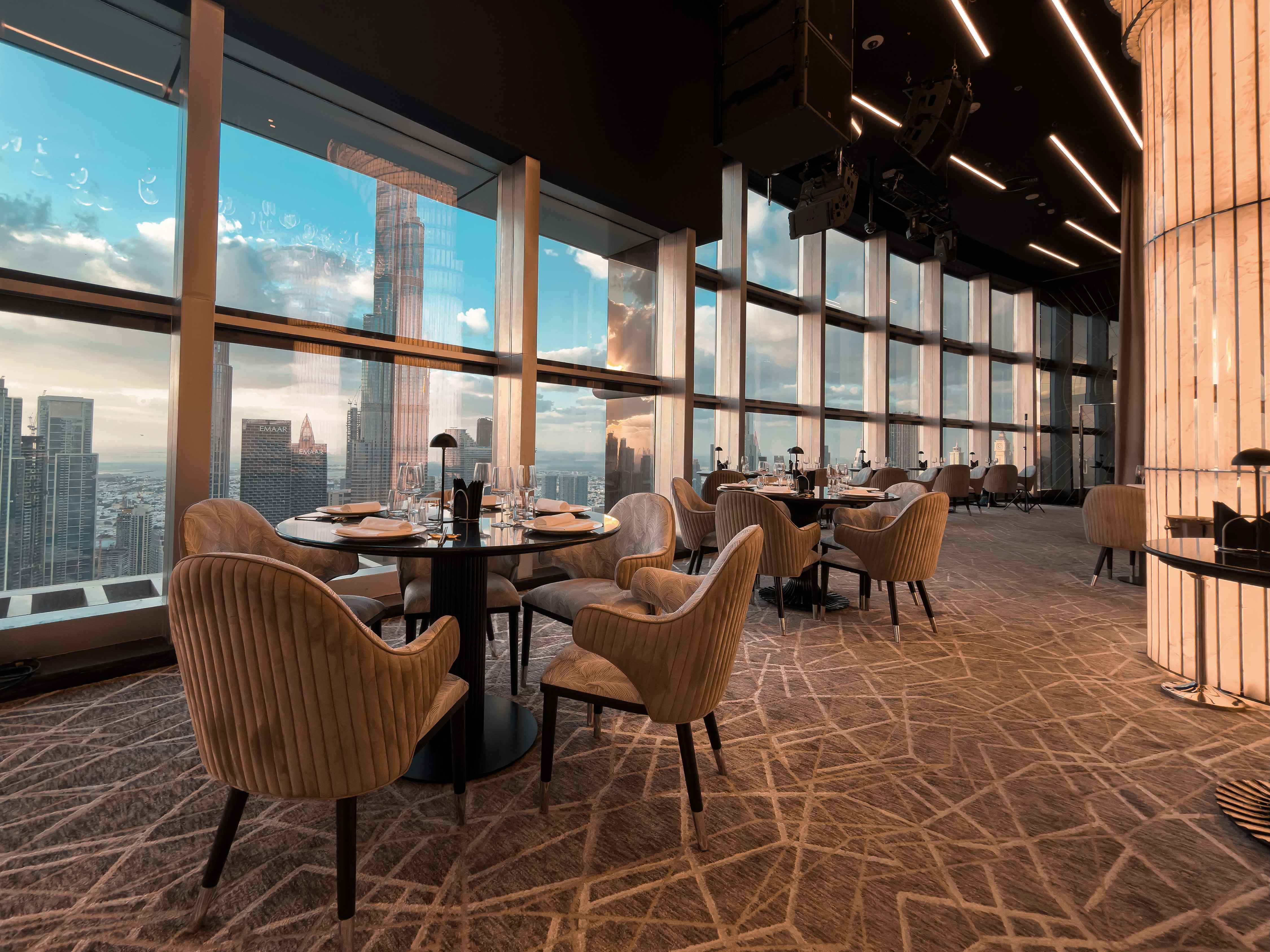 Elegant dining area at Birds Restaurant, Dubai, with city skyline views.