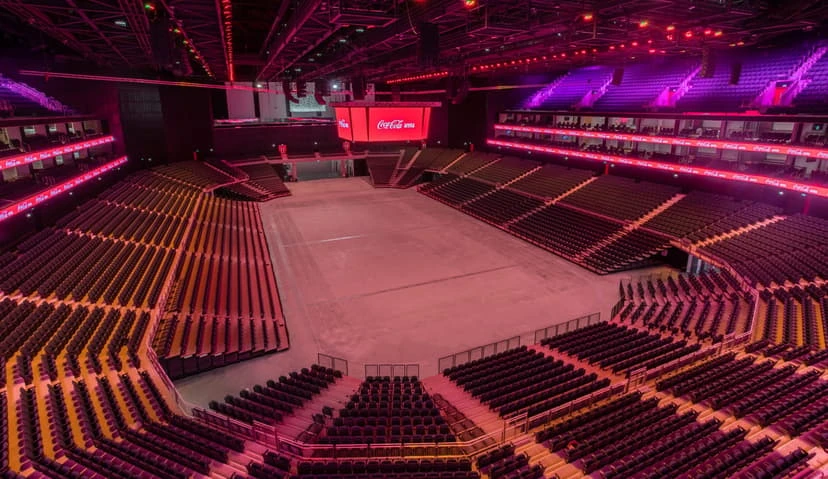 Coca-Cola Arena interior with empty seating, illuminated in red, Dubai.