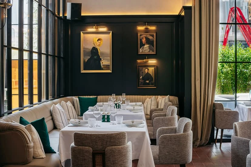 Elegant dining area at Chic Nonna Dubai with framed portraits.