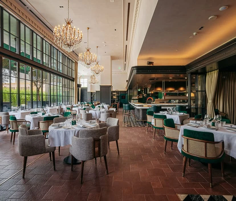 Elegant dining area at Chic Nonna Dubai with chandeliers and large windows.