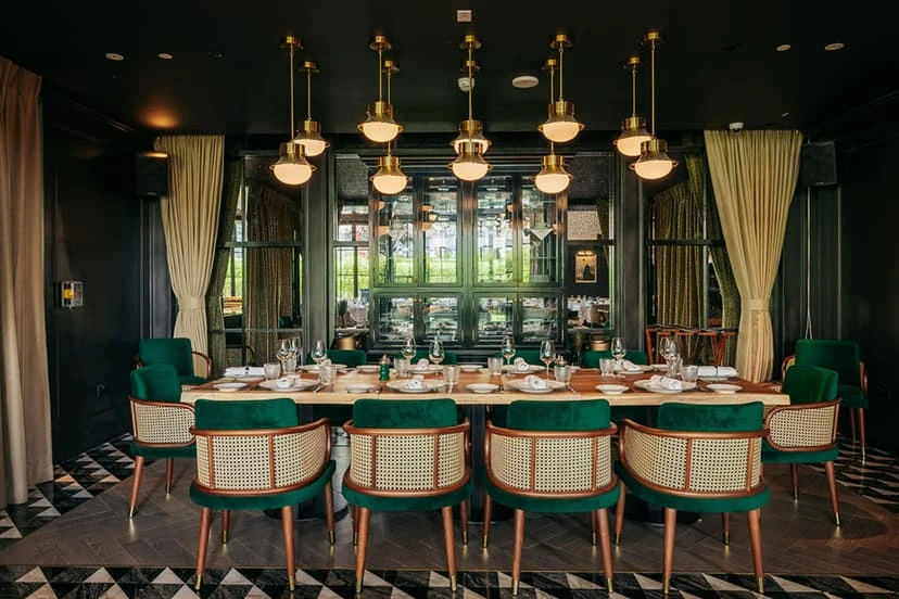 Elegant dining room at Chic Nonna Dubai with green chairs.