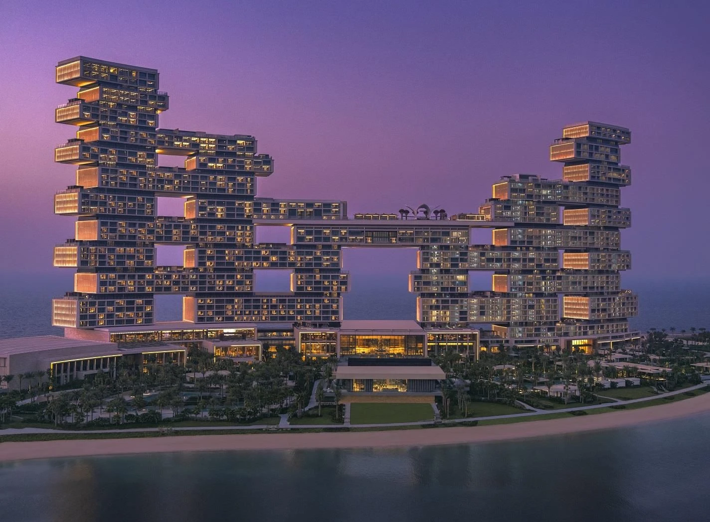 Atlantis The Royal Dubai illuminated at dusk, overlooking the sea.