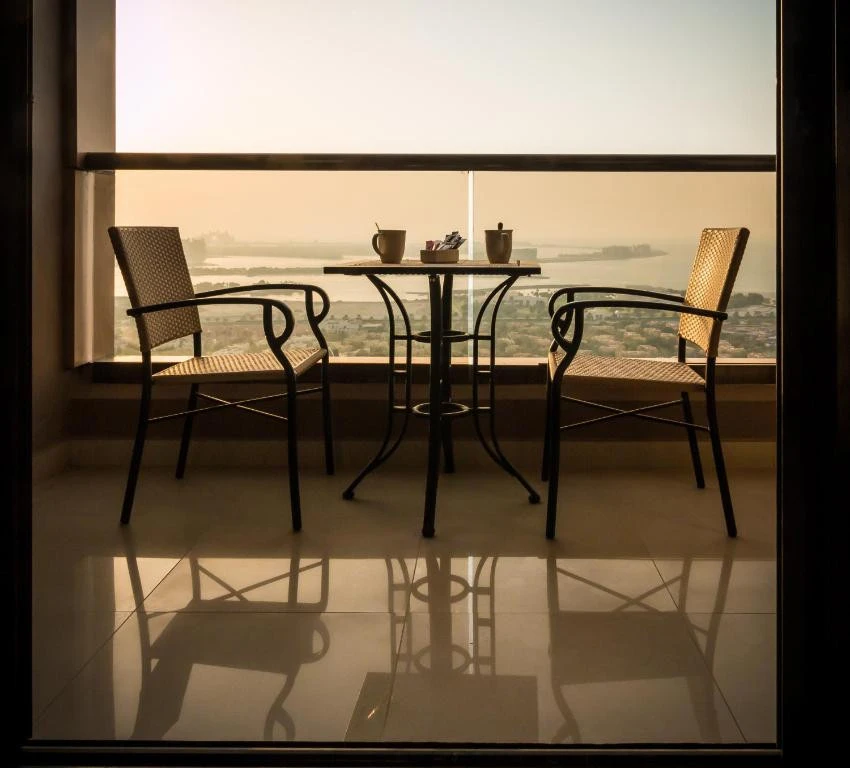 Balcony view with chairs, table at Two Seasons Hotel, Dubai.