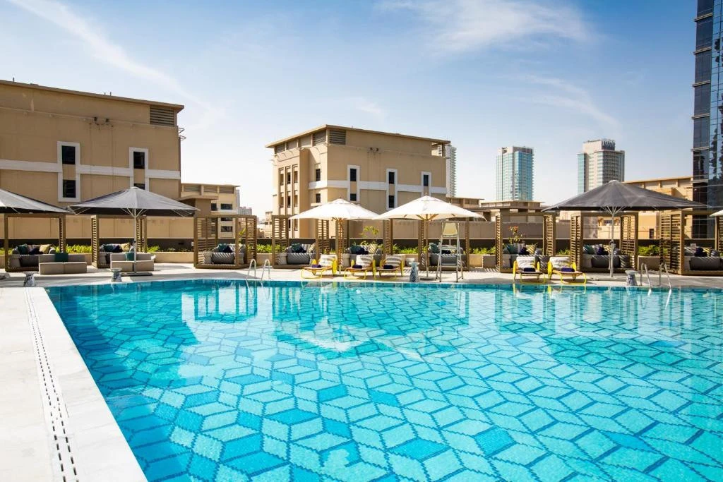 Outdoor pool at Zabeel House The Greens, Dubai, with sun loungers.