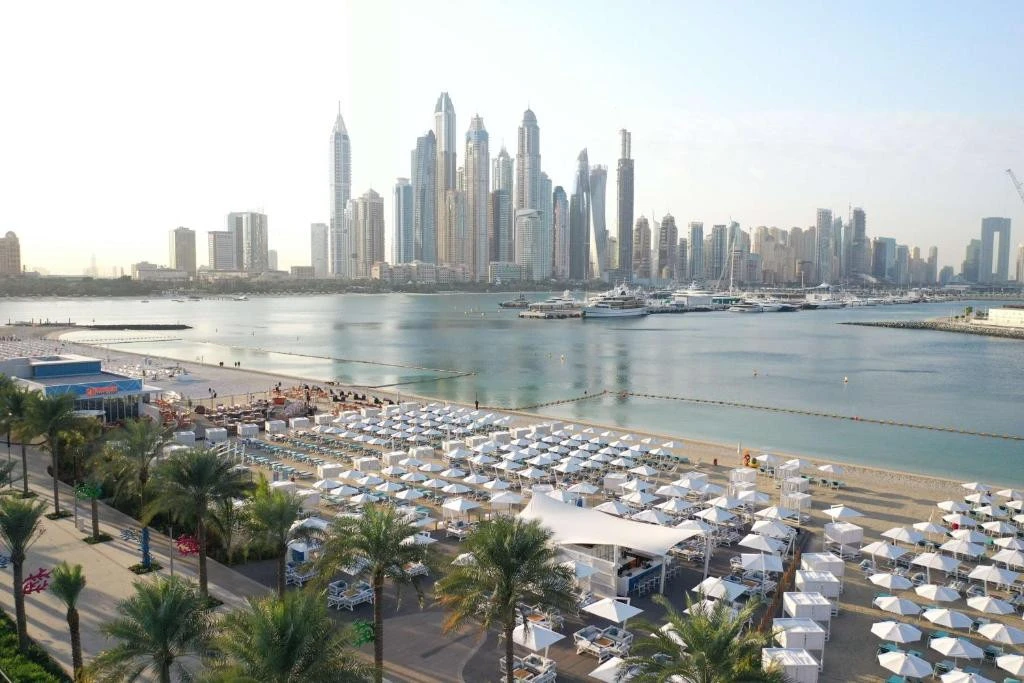 Hilton Dubai Palm Jumeirah beach with city skyline view.