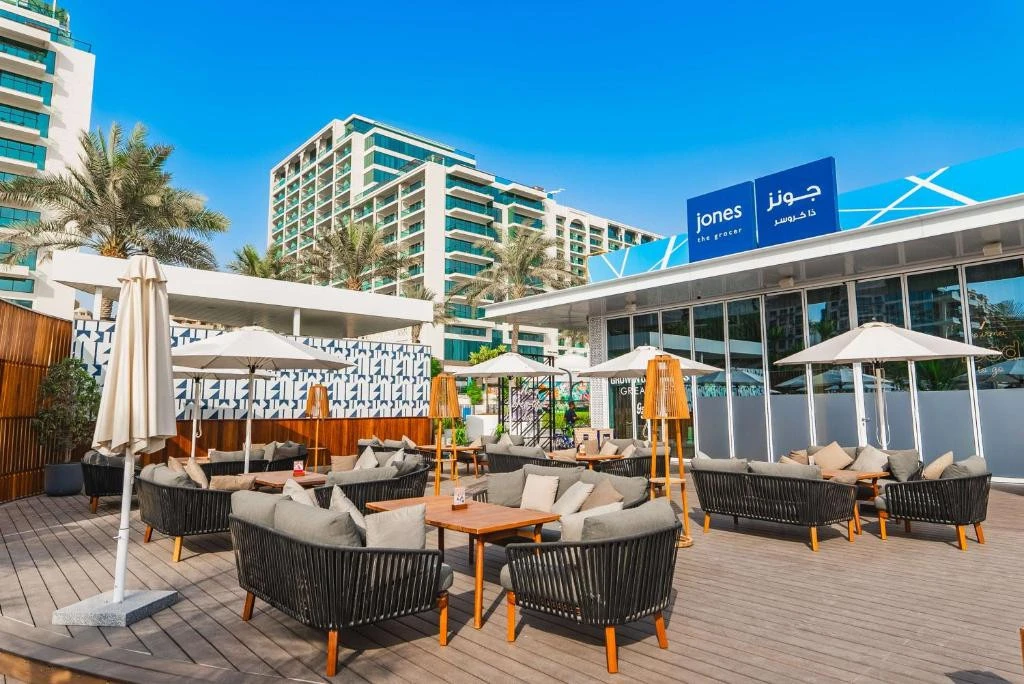 Outdoor seating at Hilton Dubai Palm Jumeirah with umbrellas and sofas.