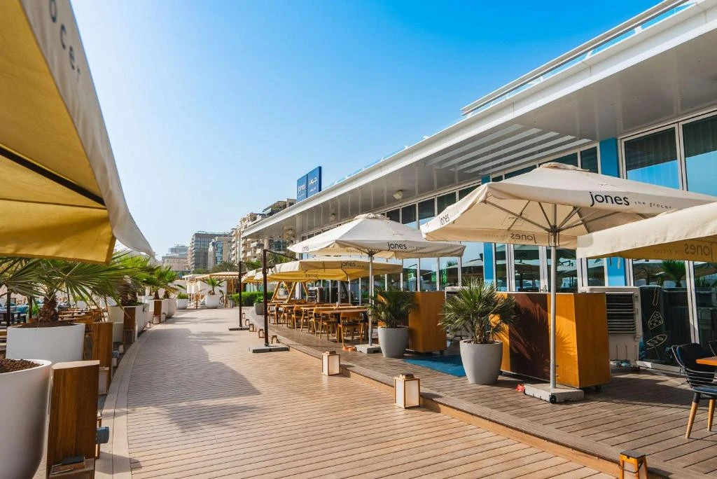 Outdoor dining area at Hilton Dubai Palm Jumeirah, sunny day.
