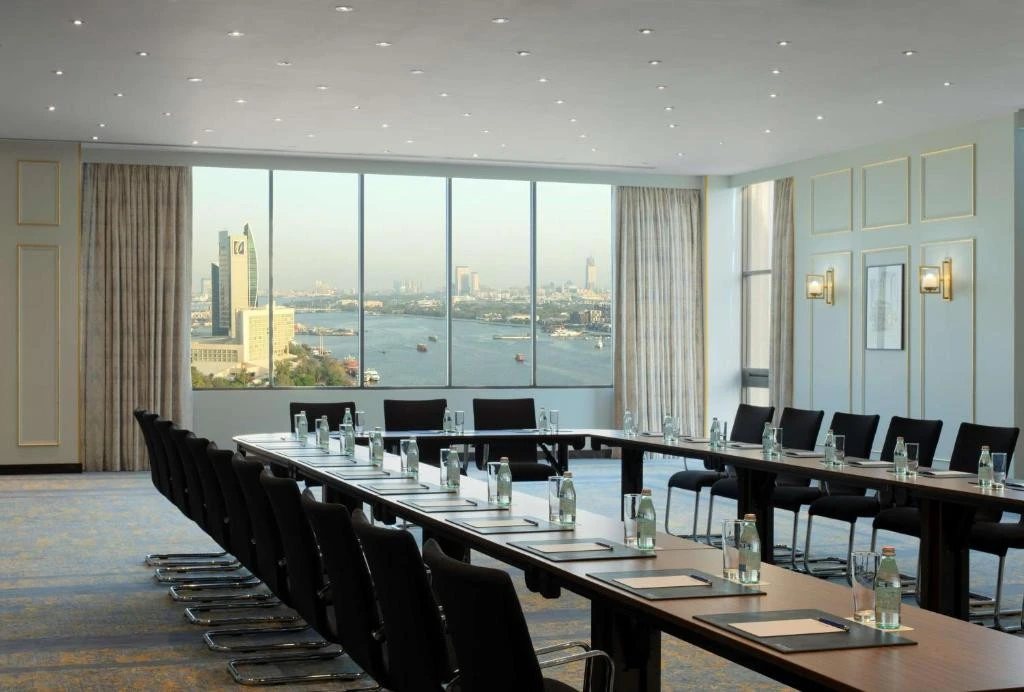 Conference room at Radisson Blu Hotel, Dubai Deira Creek overlooking cityscape.