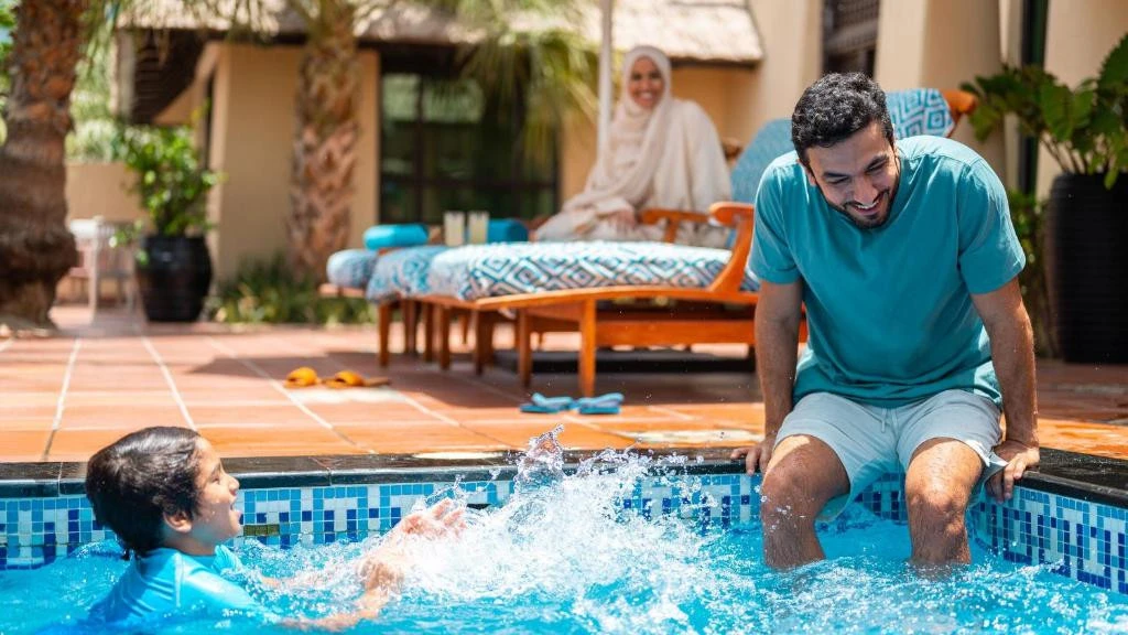 Family enjoying poolside at Jumeirah Beach Hotel, Dubai.