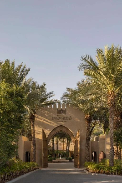 Entrance of Bab Al Shams Desert Resort, Dubai surrounded by palm trees.