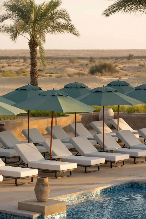 Poolside loungers and umbrellas at Bab Al Shams Desert Resort, Dubai.