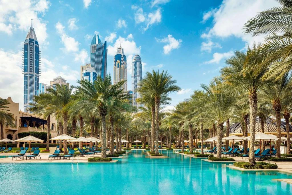 Luxurious poolside at One&Only Royal Mirage, Dubai with palm trees.