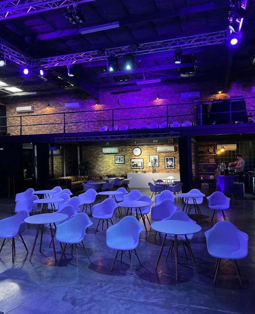 Warehouse Four Dubai, modern event space with purple lighting and seating.