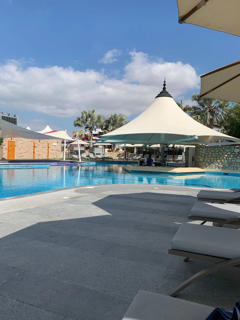 Poolside view at Emirates Golf Club, Dubai with sun loungers.