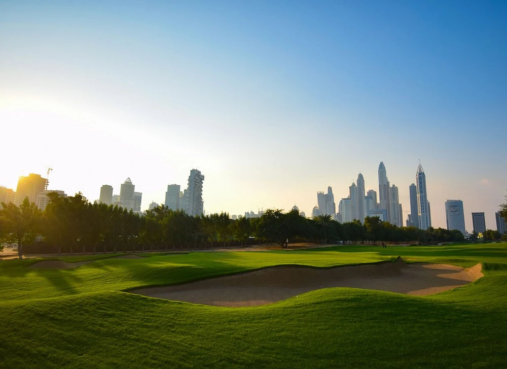 Emirates Golf Club green with Dubai skyline in background.