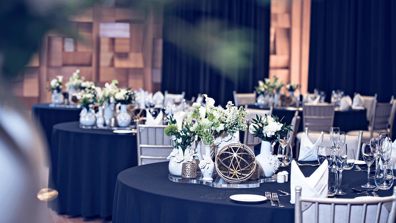 Elegant table setting at Dubai Opera with floral centerpieces.