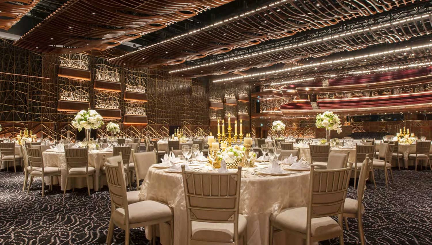 Elegant banquet setup at Dubai Opera, featuring floral centerpieces and candles.