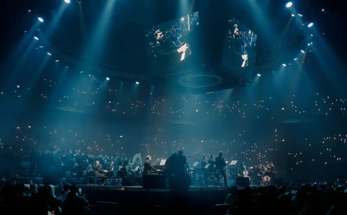 Orchestra performing at Coca-Cola Arena, Dubai, under blue stage lights.