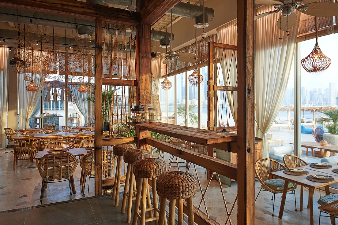 Koko Bay Dubai interior with wooden decor and beach view.