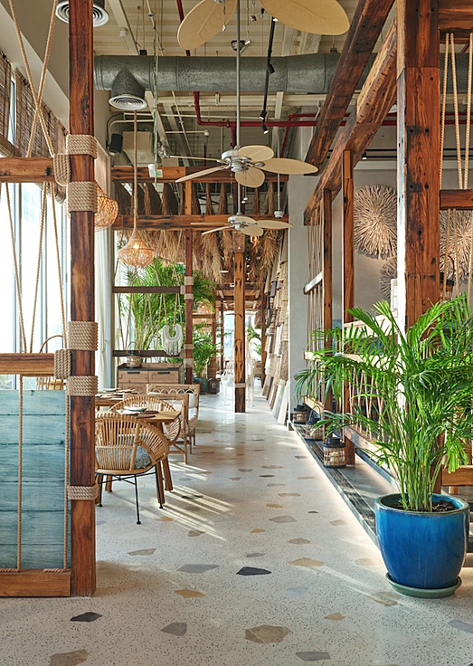 Koko Bay Dubai interior with wooden decor and tropical plants.