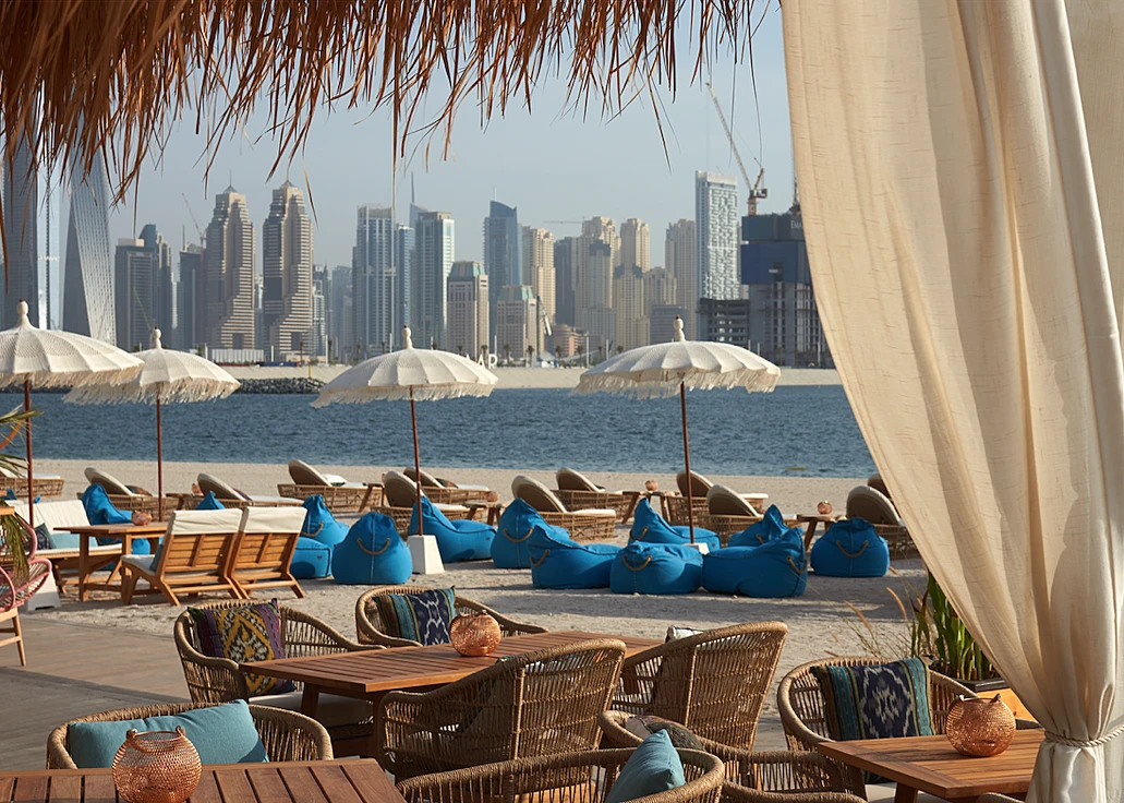 Koko Bay Dubai beachside seating with city skyline view.