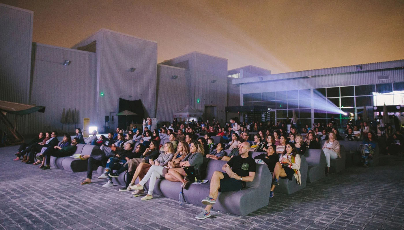 Outdoor movie screening at Cinema Akil, Dubai with seated audience.