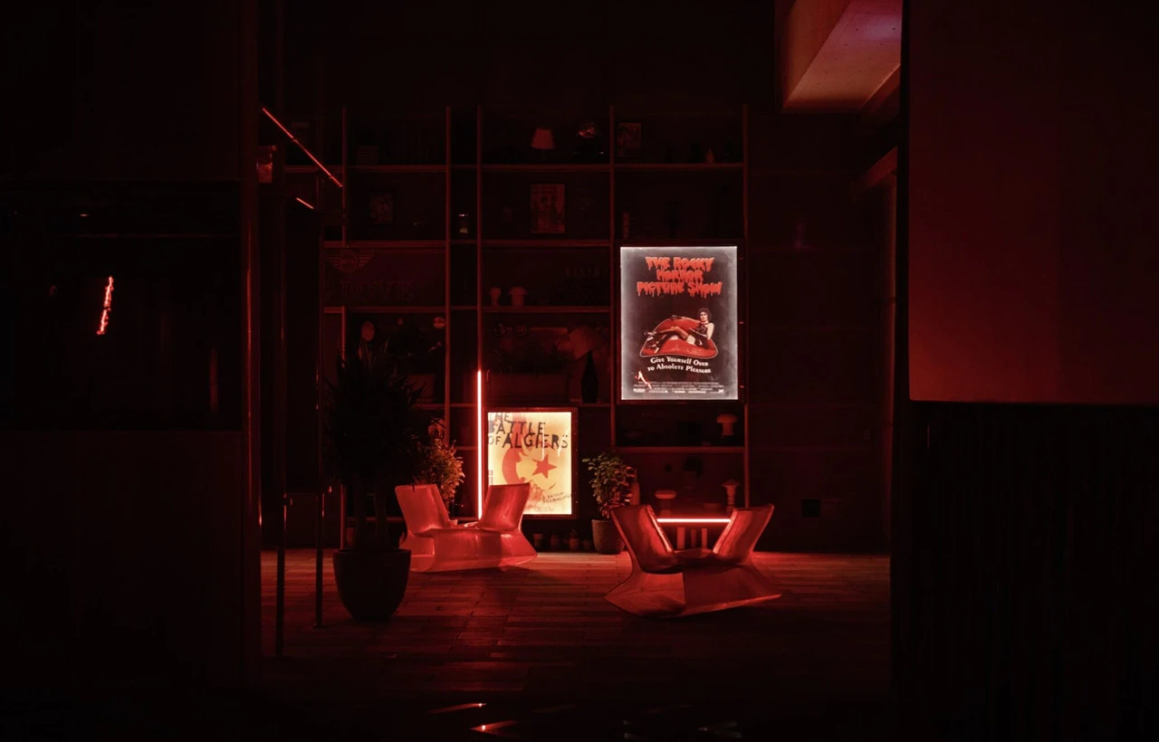 Cinema Akil lounge with red lighting, posters on wall, Dubai.