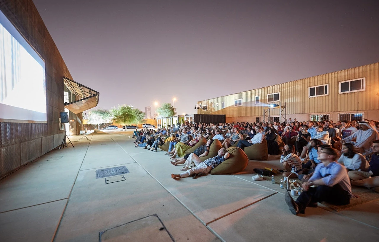 Nighttime outdoor film event at Cinema Akil, Dubai, with audience seated.