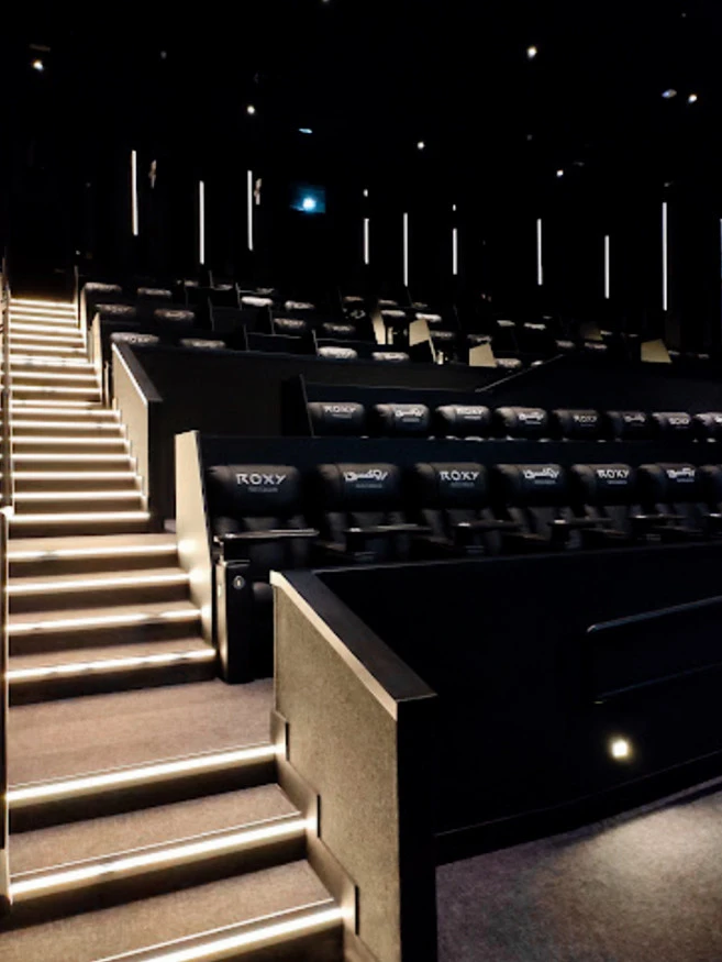 Interior of Roxy Cinema Al Khawaneej, Dubai, with illuminated stairs.