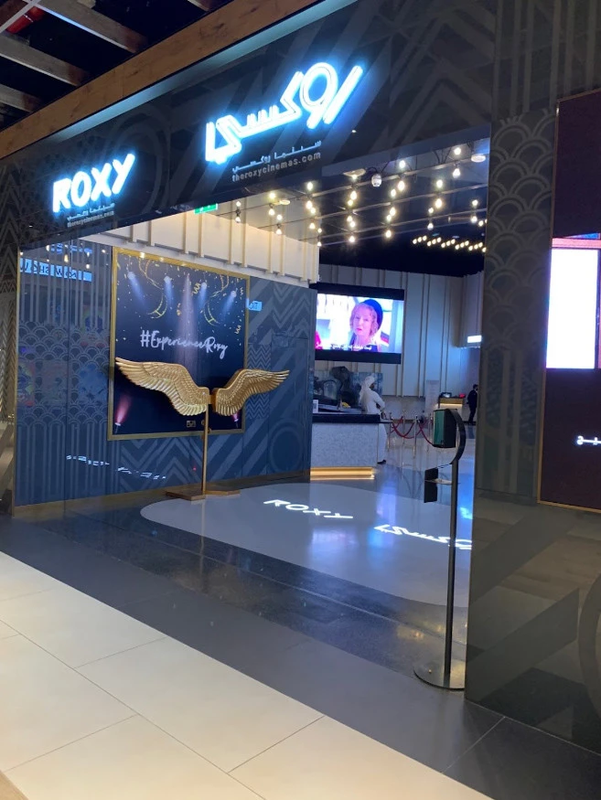 Entrance of Roxy Cinema Al Khawaneej, Dubai, with illuminated signage.