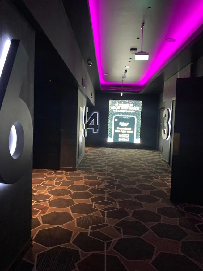 Roxy Cinema Al Khawaneej hallway with illuminated theater numbers, Dubai.